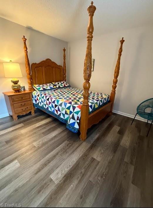 bedroom featuring baseboards and wood finished floors