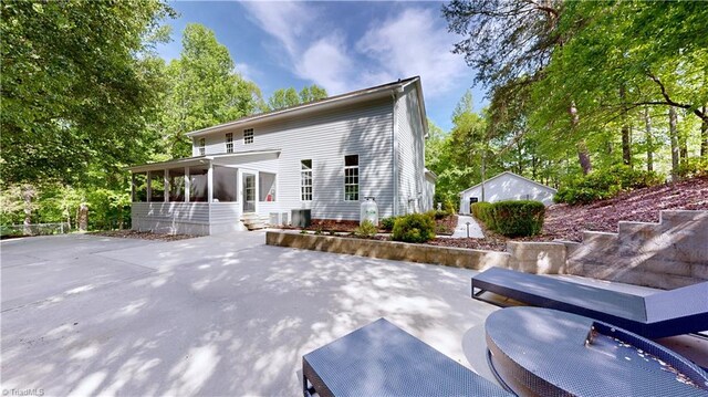 back of property with a patio area and a sunroom