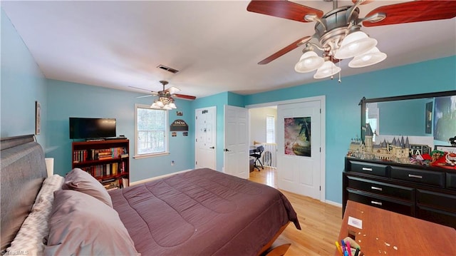 bedroom with visible vents, ceiling fan, light wood finished floors, and baseboards