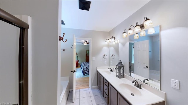 bathroom with ceiling fan, ensuite bath, double vanity, and a sink