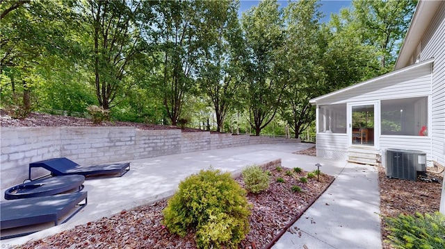 view of yard featuring central AC, a sunroom, and a patio area