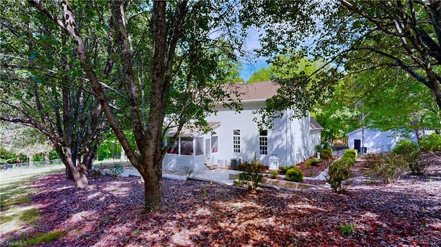 view of property exterior with fence and a sunroom