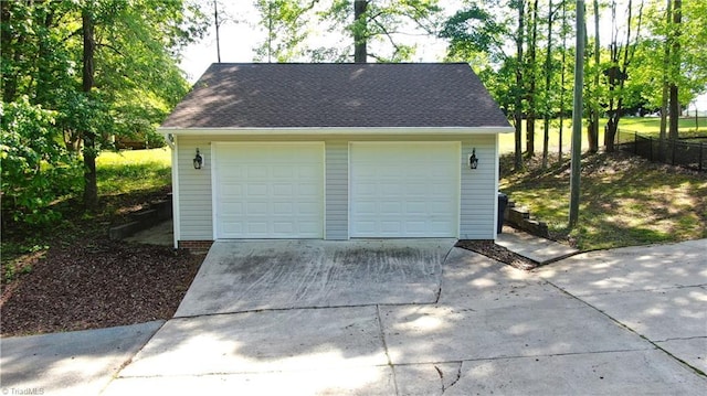 detached garage featuring fence