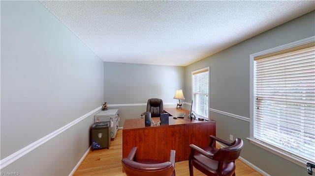 office space featuring a textured ceiling, light wood-style floors, and baseboards