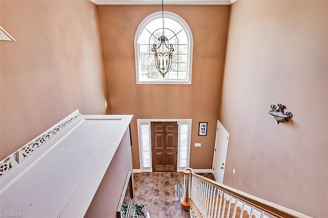 foyer featuring ornamental molding and an inviting chandelier