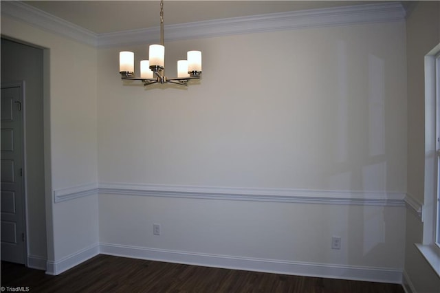 unfurnished dining area with dark wood-type flooring, ornamental molding, and a chandelier