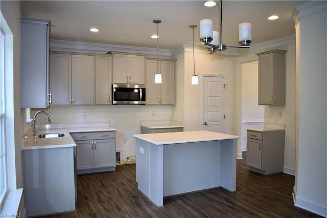 kitchen featuring sink, a center island, decorative light fixtures, dark wood-type flooring, and gray cabinets