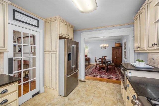 kitchen featuring hanging light fixtures, ornamental molding, cream cabinetry, light hardwood / wood-style flooring, and high end refrigerator