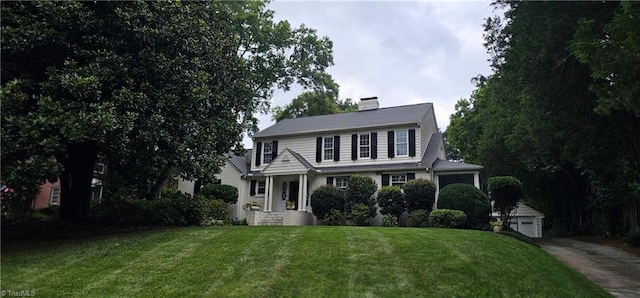 view of front of home featuring a front lawn, an outbuilding, and a garage