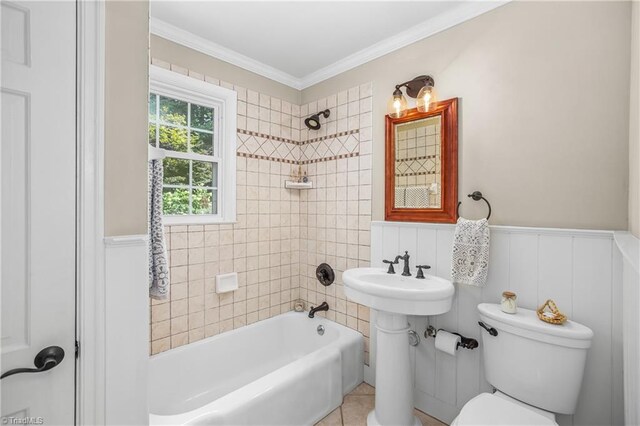 bathroom with tiled shower / bath combo, tile patterned flooring, ornamental molding, and toilet