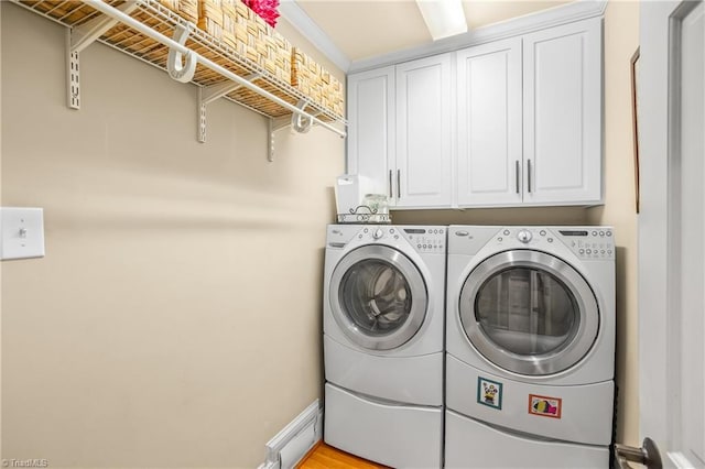 washroom featuring light hardwood / wood-style flooring, cabinets, and separate washer and dryer