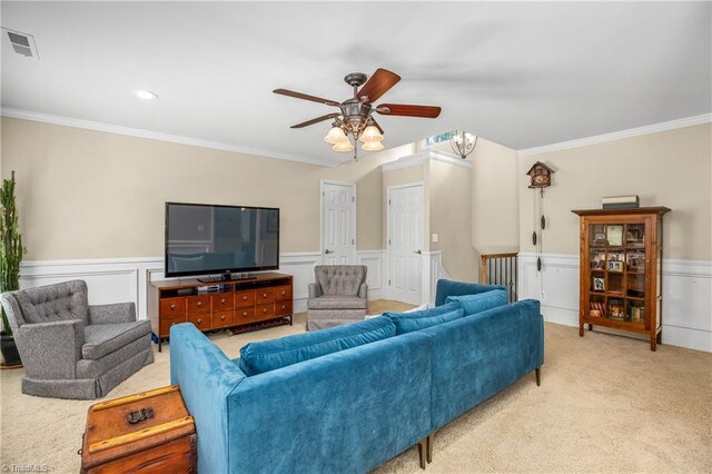 carpeted living room featuring ceiling fan and crown molding