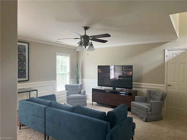 living room with ceiling fan, ornamental molding, and light carpet