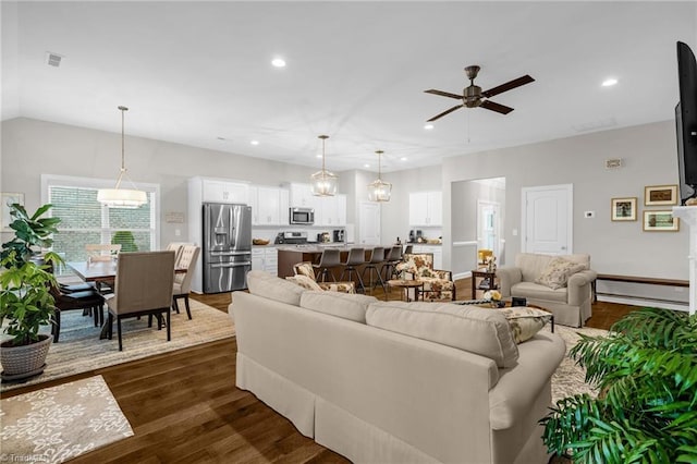 living room with dark wood-style flooring, a ceiling fan, vaulted ceiling, and recessed lighting