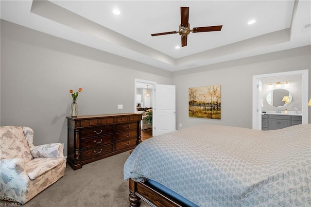 bedroom with a ceiling fan, connected bathroom, a tray ceiling, carpet flooring, and recessed lighting