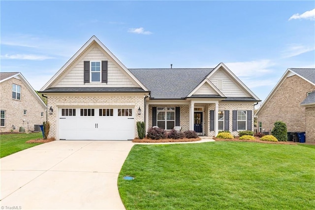 craftsman house with brick siding, driveway, a front yard, and roof with shingles