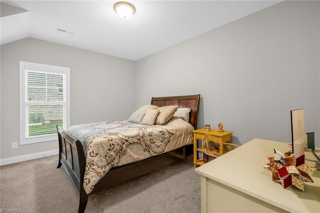 bedroom with light carpet, vaulted ceiling, visible vents, and baseboards