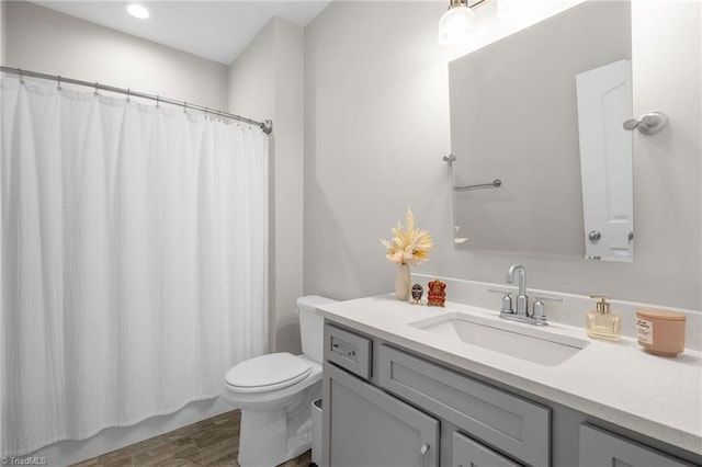 bathroom featuring recessed lighting, wood finished floors, toilet, and vanity