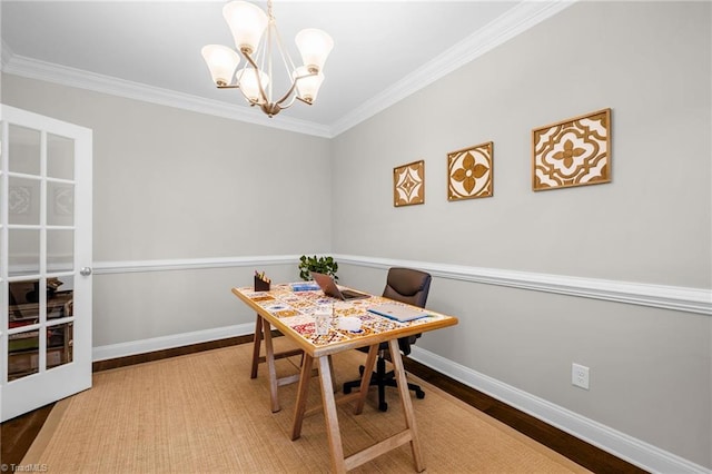 dining room featuring wood finished floors, a notable chandelier, baseboards, and ornamental molding