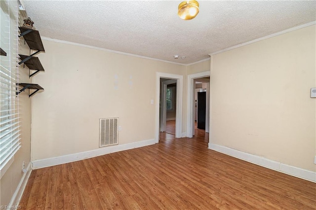 725 S Beaumont Ave, Burlington, NC 27217 - unfurnished room featuring baseboards, wood finished floors, a textured ceiling, and visible vents