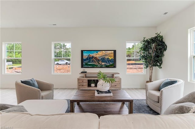 living room with baseboards, a healthy amount of sunlight, and wood finished floors