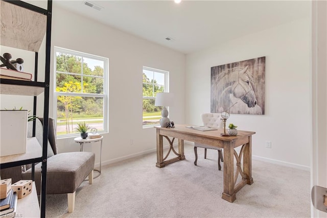 office with baseboards, visible vents, and light carpet