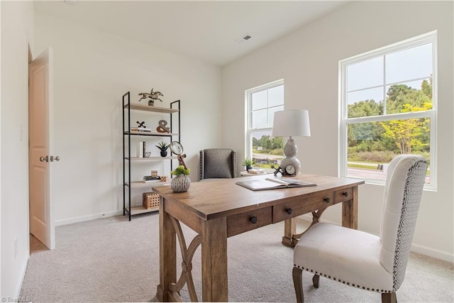 office with baseboards, visible vents, and light carpet