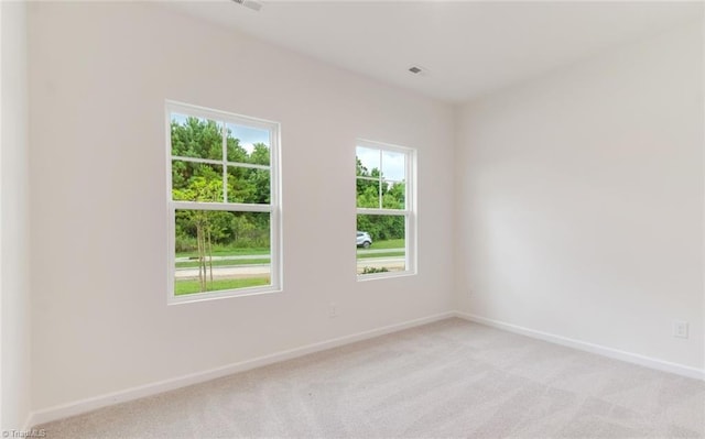 empty room featuring baseboards and light colored carpet