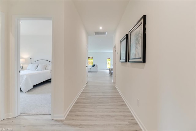 corridor featuring light wood finished floors, visible vents, recessed lighting, and baseboards