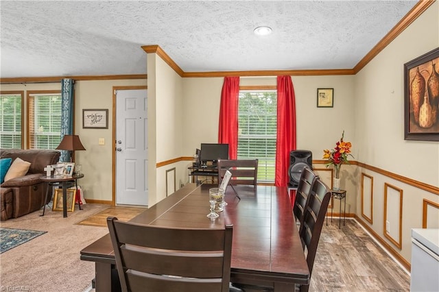 dining area with carpet flooring, plenty of natural light, ornamental molding, and a textured ceiling