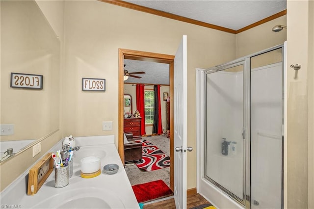 bathroom with ceiling fan, crown molding, walk in shower, and vanity