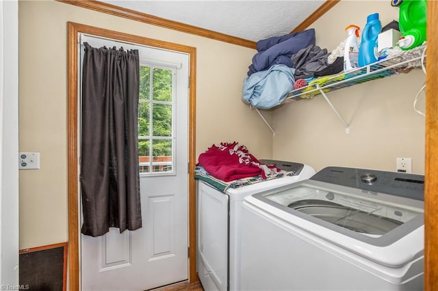 laundry area featuring a textured ceiling, separate washer and dryer, and crown molding