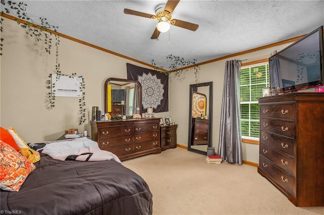 carpeted bedroom with ceiling fan, a textured ceiling, and ornamental molding