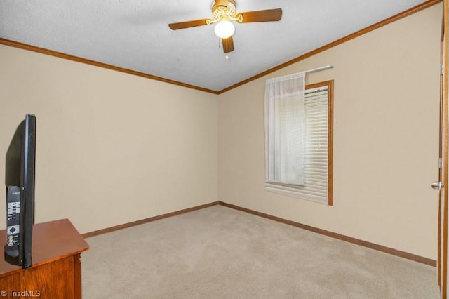 spare room with light carpet, ceiling fan, and ornamental molding