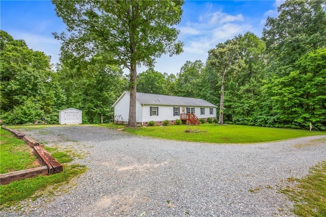 ranch-style home with a front lawn, an outdoor structure, and a garage