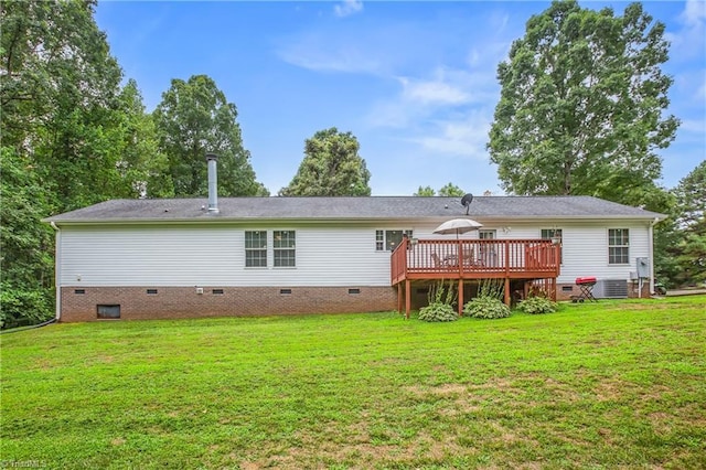 rear view of property featuring a deck and a lawn