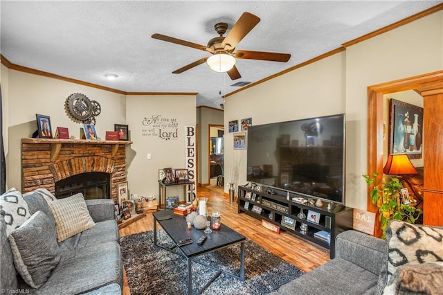 living room featuring a fireplace, hardwood / wood-style floors, a textured ceiling, and ornamental molding