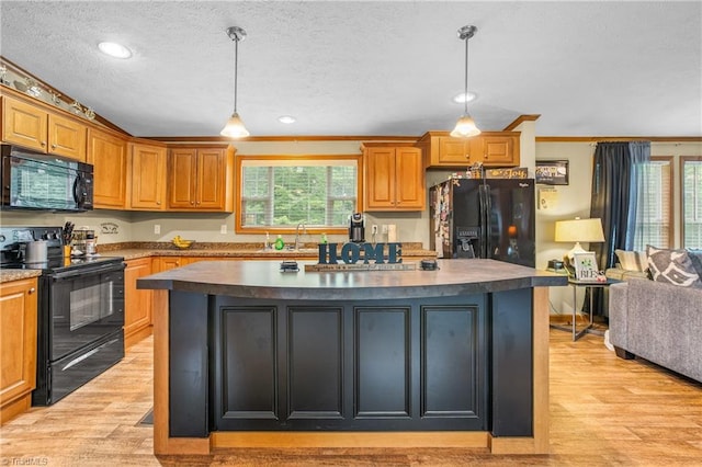 kitchen with a kitchen island, a healthy amount of sunlight, and black appliances