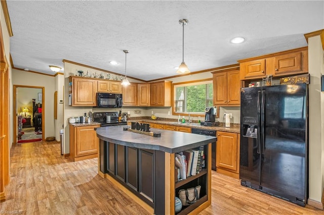 kitchen with a center island, lofted ceiling, black appliances, ornamental molding, and decorative light fixtures