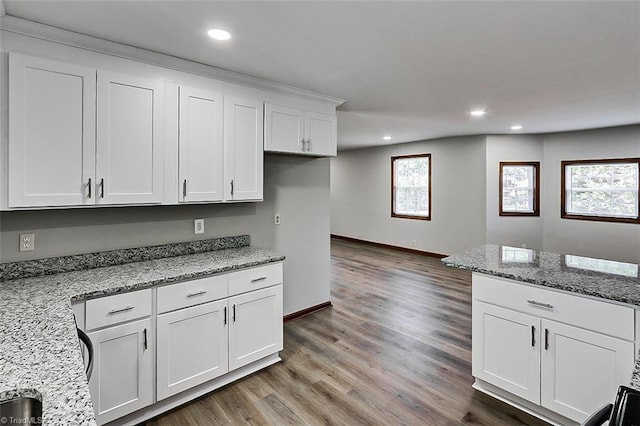 kitchen featuring a wealth of natural light, white cabinets, and light stone countertops