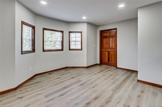 empty room with recessed lighting, light wood-style flooring, and baseboards