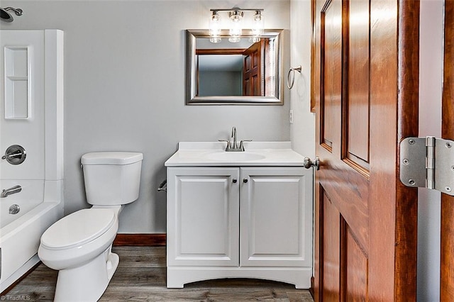 full bathroom with toilet, wood finished floors, vanity, and baseboards