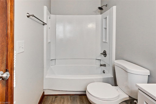 bathroom with bathing tub / shower combination, vanity, toilet, and wood finished floors