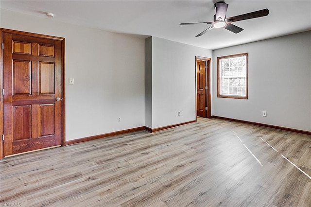 spare room featuring light wood-style floors, ceiling fan, and baseboards