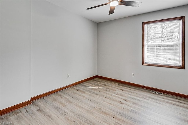 empty room featuring light wood-style floors, visible vents, ceiling fan, and baseboards