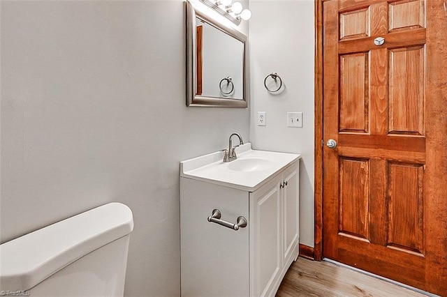 bathroom featuring vanity, toilet, and wood finished floors