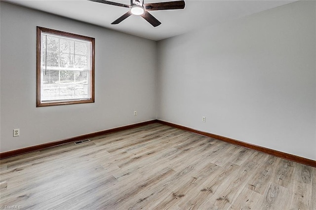 empty room featuring light wood finished floors, baseboards, visible vents, and ceiling fan