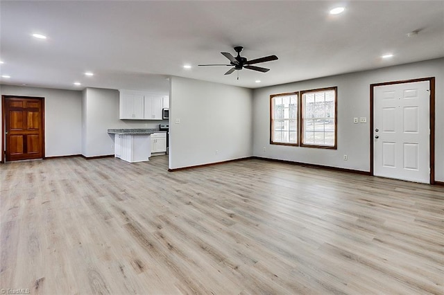 unfurnished living room featuring light wood-style flooring, baseboards, and recessed lighting