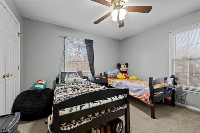 carpeted bedroom featuring baseboards, a closet, and ceiling fan