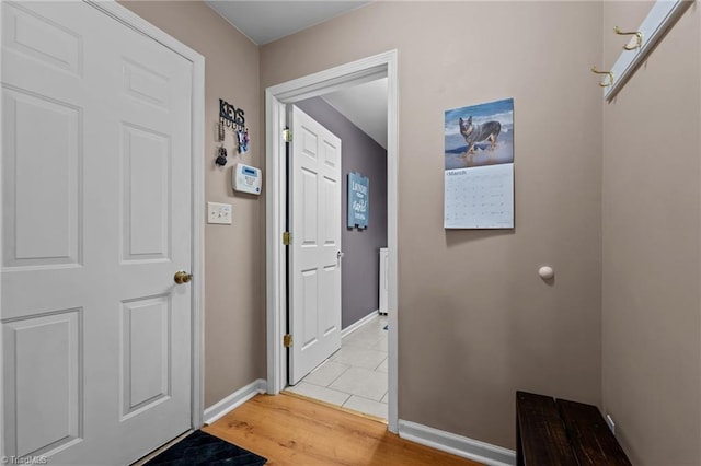 foyer with light wood-type flooring and baseboards